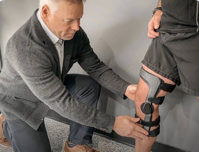Steve fitting a custom knee brace during an in-person assessment